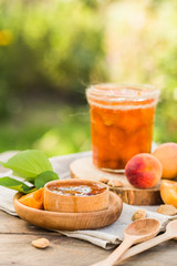 Apricot jam and ripe apricots on the wooden natural table.