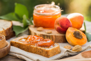 Apricot jam and ripe apricots on the wooden natural table.