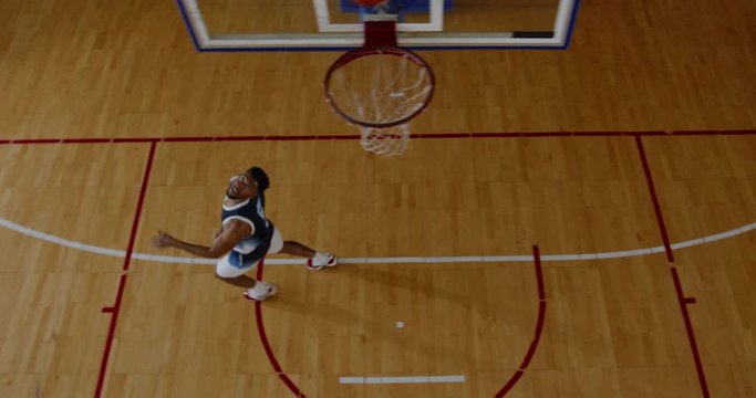 OVERHEAD HIGH ANGLE JIB SHOT African American Black College Male Basketball Player Fails To Dunk Alone On The Indoor Court. 4K UHD 50 FPS SLOW MOTION RAW Graded Footage