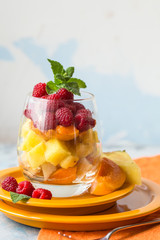 Fresh healthy fruit salad. Selective focus. Natural eating. Fruit salad on white background - diet, healthy breakfast. Healthy food dinner table. Gourmet food. Copy space. Tropical fruit.