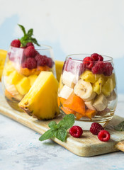 Fresh healthy fruit salad. Selective focus. Natural eating. Fruit salad on white background - diet, healthy breakfast. Healthy food dinner table. Gourmet food. Copy space. Tropical fruit.