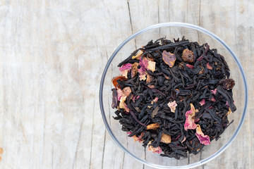 Loose black tea flavored with flower petals and fruits in a glas