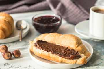 breakfast with croissants. fresh crispy croissants and coffee on a light background, top view