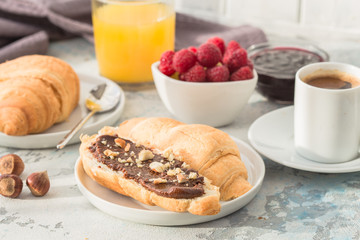 breakfast with croissants and berry, orange juice. fresh crispy croissants and coffee on a light background, top view/