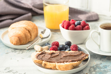 breakfast with croissants and berry, orange juice. fresh crispy croissants and coffee on a light background, top view/