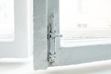 An open window in the entrance. White lock on the window frame. Repair in the summer in an apartment building