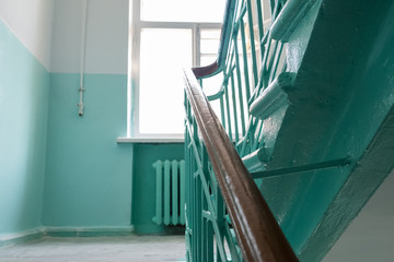 Staircase at the entrance of an apartment building. View from below. You can see the railing, grille, window. New repairs in the entrance.