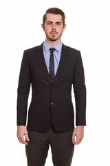 Portrait of young handsome bearded businessman in suit