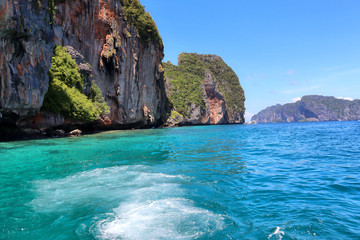 Fototapeta na wymiar boat ride on the sea, exotic James Bond islands against the blue sea, waves of spray in Thailand