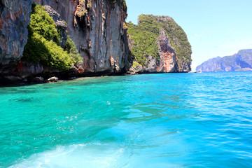 Fototapeta na wymiar boat ride on the sea, exotic James Bond islands against the blue sea, waves of spray in Thailand