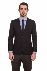 Portrait of young handsome bearded businessman in suit