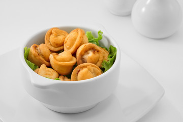 close up view of plate with fried dumplings  on white background.