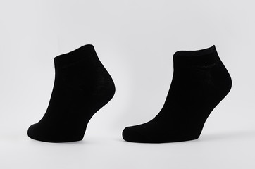 Blank black cotton short socks on invisible mannequin foot as mock up for advertising, branding,...