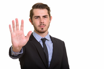 Portrait of young handsome bearded businessman in suit