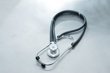 Medical phonendoscope (stethoscope) on a metal table. A diagnostic device for listening to sounds coming from the heart, blood vessels, and other organs.