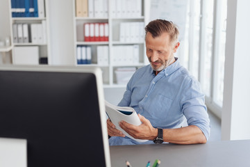 Businessman reading from a handheld notebook