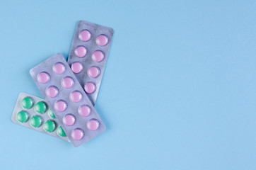 Pills blisters composition on blue background. Flat lay.