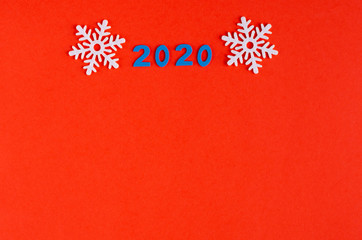 Number 2020 and white snowflakes composition on red background, New Year and Christmas holiday.