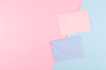 Blue paper envelope composition on pink background.