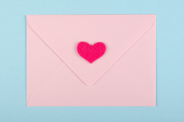 Paper envelope with red heart composition on blue background.