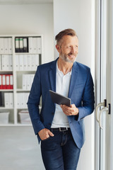 Smart businessman standing waiting with a tablet