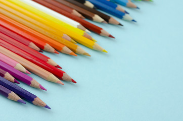 Colored pencils composition on blue background. Flat lay.