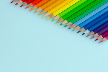 Colored pencils composition on blue background. Flat lay.