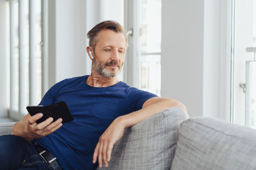 Middle-aged man relaxing at home with his music