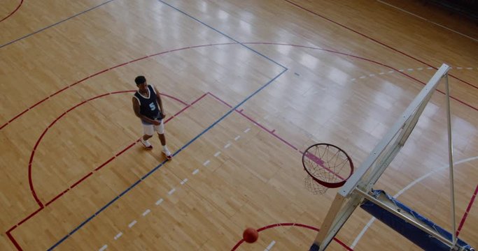 OVERHEAD HIGH ANGLE JIB SHOT African American Black College Male Basketball Player Practicing Shots Alone On The Indoor Court. 4K UHD 50 FPS SLOW MOTION RAW Graded Footage