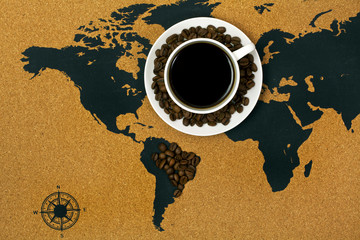 Cup of black hot coffee on a map with Brasil made of coffee beans. Top view.