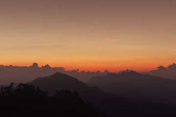 silhouette shot image of mountain and sunset sky in background.