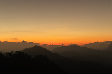 silhouette shot image of mountain and sunset sky in background.