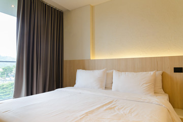 stacking of pillows on bed, white bed sheets with wooden bedhead