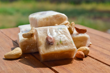 sonpapdi and nuts on wooden table