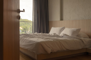 wrinkled white blanket with soft pillows on comfortable bed in the morning. messed up after nights...