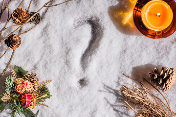 Dry branch with cones, candle, christmas decorations, on the night snow. Top view. Winter. copy space. Question mark. Still life