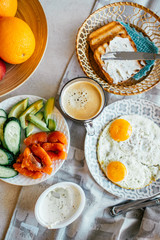 Top view of breakfast with egg, salmon, avocado, cucumber,cup of coffee and grilled bread with cream cheese. Home made food. Norway breakfast.