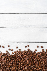 Overhead shot of roasted coffee beans on rustic wooden background with copyspace