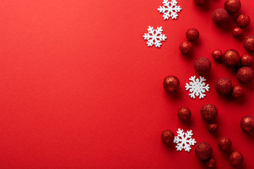 Christmas flat lay background with fir tree, with Christmas tree made of red toys balls decorated golden confetti in red envelope on red background. New year concept. Top view.
