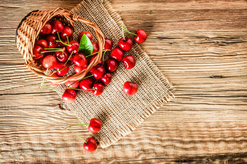 Fresh ripe cherries on wooden table top view. Pair of cherry with leaf.