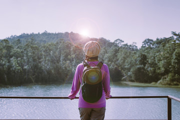 Happy backpacking woman standing and looking beautiful view at nature,Back view