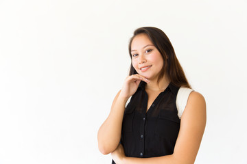 Fototapeta premium Positive smiling student girl touching chin and looking at camera. Young Latin woman in casual standing isolated over white background. Female studio portrait concept
