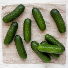 Fresh organic mini baby cucumbers on cloth, view from above. Flat lay, top view, overhead.