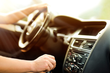 Man using gear on car manual gearbox for driving close up. Vehicle dashboard in background blured....