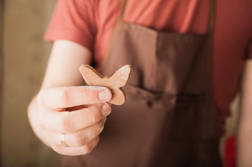 Men's hands and dough close-up. Baking gingerbread Christmas and Easter gingerbread cookies. A man in the kitchen is preparing cookies in an apron and copy space.