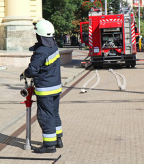 Firefighter and a firetruck on the street