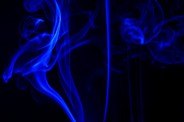 blue smoke from aromatic sticks on a black background