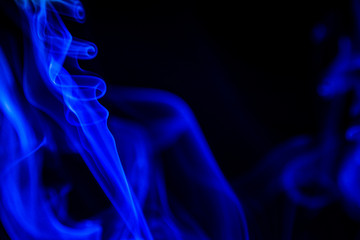 Obraz premium blue smoke from aromatic sticks on a black background