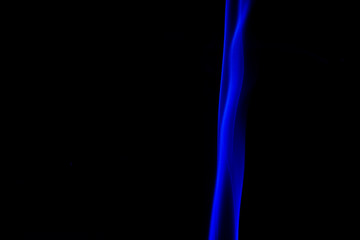 Obraz premium blue smoke from aromatic sticks on a black background