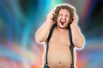 Fototapeta na wymiar Funny fat guy listens to music on headphones.